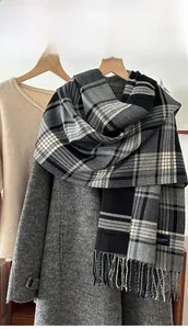 Detail of grey plaid scarf featuring soft cashmere-like texture and handmade fringes