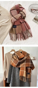 Close-up of a thick check pattern scarf with long tassels and a rectangular fabric label