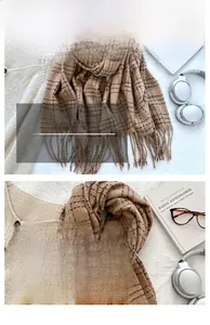 Close-up of soft brown plaid winter scarf with fringe details and woven texture