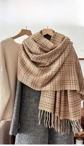 Close-up of winter plaid scarf with brown check pattern and long tassel details