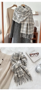 Detailed view of a soft black and white checkered scarf featuring classic tassel edges