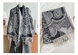 Detail of gray and white paisley pashmina shawl showing soft fabric texture and fringe tassels