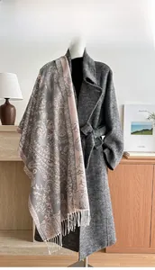 Close-up of pink and grey paisley scarf with fringe on a dark grey wool coat
