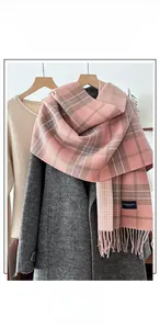 Detail of pink plaid imitation cashmere scarf with thick tassels and woven texture