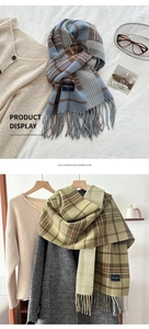 Detail of elegant imitation cashmere plaid scarf with fringed edges and woven logo patch