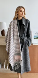 Dettaglio dello scialle in cashmere pied-de-poule morbido con nappe su cappotto grigio