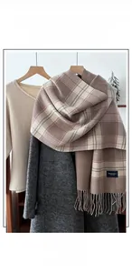Detail of soft double-sided plaid scarf with tassel edges and thick warm texture