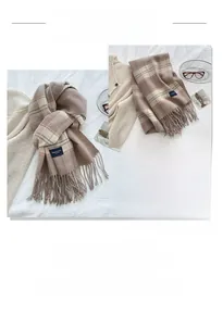 Close-up of thick brown plaid scarf texture with soft tassels and warm knit fabric