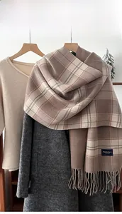Classic plaid scarf with fringe tassels layered over cozy winter knitwear and grey coat