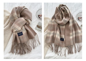 Detail of red plaid scarf with tassels and Elegant Classic label in a cozy winter setting