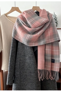 Detailed view of pink and grey checkered winter scarf with handmade tassel edges