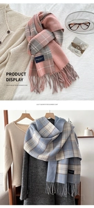 Detail of plaid imitation cashmere scarf with long tassels and elegant woven label