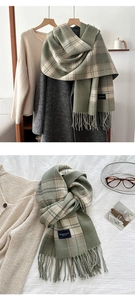 Detail of forest green and beige plaid scarf with tassels and elegant woven brand label
