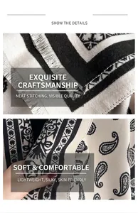Macro detail of thick black and white paisley knit scarf showing fringe and soft fabric
