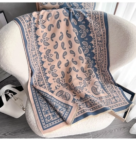 Nahaufnahme von blauem Paisley-Jacquard-Schal mit Quastenrand und rosa Bordüre