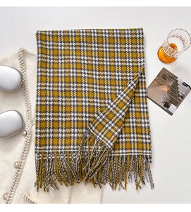 Close-up of yellow and grey plaid scarf featuring soft texture and long fringe tassels