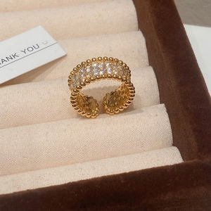 Macro detail of gold-plated open ring featuring three rows of pavé zircons and beaded edges