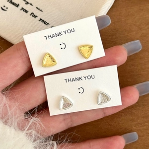 Geometric triangle stud earrings in gold and silver finish with textured grid pattern
