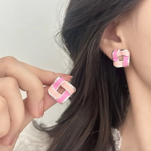 Geometric hollow square enamel stud earrings in pink and silver on a female model
