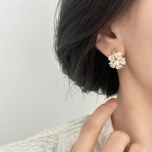 Boucles d'oreilles fleurs blanches élégantes avec perles et cristaux sur un mannequin