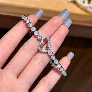 Elegant silver heart bracelet with sparkling pavé diamonds and a central red gemstone