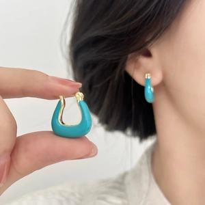 Détails des boucles d'oreilles émaillées bleu lac en forme de U et vue portée par le mannequin