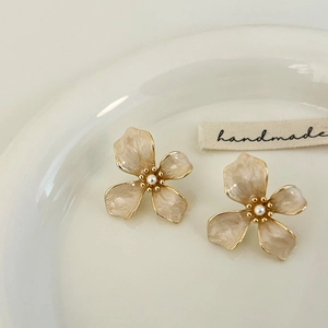Macro view of flower stud earrings with champagne enamel petals and pearl center