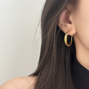 Detail von goldenen mehrschichtigen runden Ohrringen an einem Modell für einen schicken Look