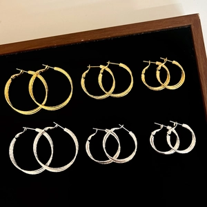 Set aus sechs gold- und silberfarbenen Creolen in drei Größen auf schwarzem Samt-Display