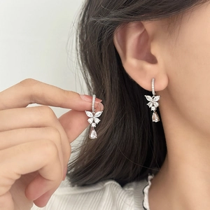 Elegant silver butterfly earrings with sparkling zircon drop pendants on model's ear