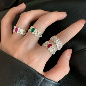 Set of four silver open rings with oval faceted gemstones in pink, green, red and clear