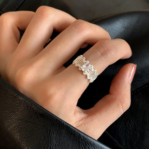 Detail of vintage lace hollow ring featuring an oval-cut zircon stone on a silver band