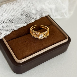 Macro detail of gold vintage ring with coral hollow pattern and oval zircon inlay