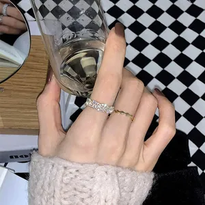 Detail of gold zircon stacked rings featuring a wavy band and a pavé stone design