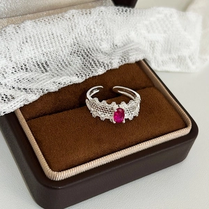 Detail of silver lace ring featuring an oval red zircon stone on vintage velvet