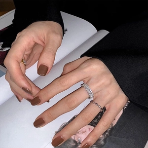 Close-up of stacked zircon open rings featuring a wide rectangular pave band on a model