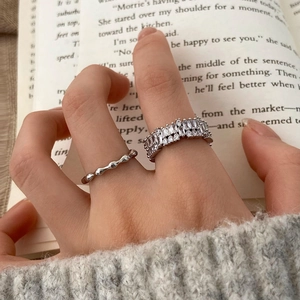 Close-up of sparkling zircon ring set on model finger with elegant book background