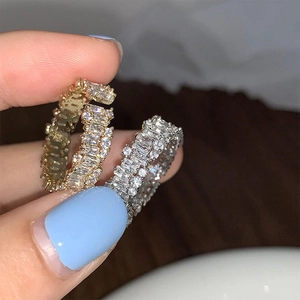 Detail of gold and silver open rings with pave set cubic zirconia on a finger
