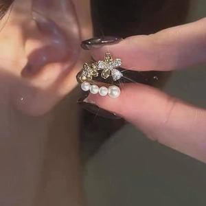Elegant gold flower ear cuff with sparkling zircons and white pearls shown on ear