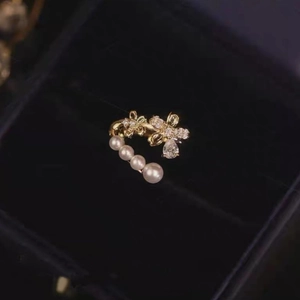 Chic gold ear cuff featuring graduating pearls and a zircon flower with pear-cut stone