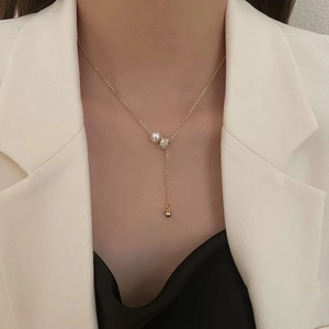 Élégant collier en Y doré avec perle blanche et curseur en strass porté par un mannequin