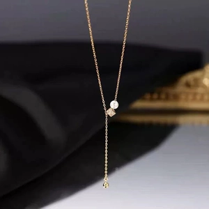 Détail du collier en Y doré avec perle blanche et pendentif carré étincelant