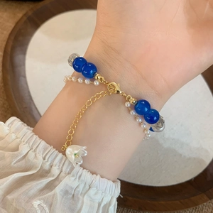 Elegant lily of the valley bracelet with blue beads, white pearls and gold flower charm