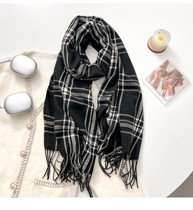 Close-up of thick knit black and white plaid scarf with decorative fringe details