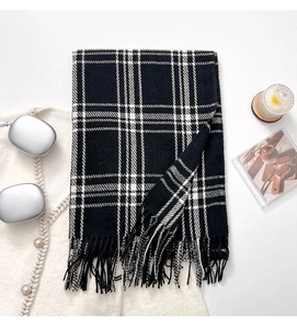 Detailed view of black and white checkered scarf with thick tassels and soft texture