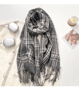 Close-up of grey and white plaid scarf with soft tassels and thick woven texture