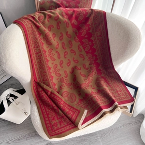 Jacquard-Schal mit Paisley-Muster in Rot und Gold und Quasten auf weißem Sessel