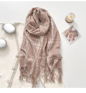 Detail of pink and white checkered scarf featuring long tassels and soft knit texture