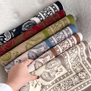 Dicke Paisleymuster Strickschals in verschiedenen Farben für winterliche Wärme gestapelt