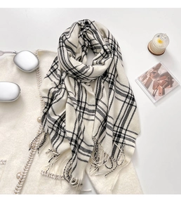 Detail of black and white checkered scarf featuring soft fringe and thick knit texture